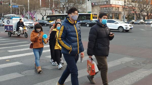 Люди в защитных масках на улице Пекина