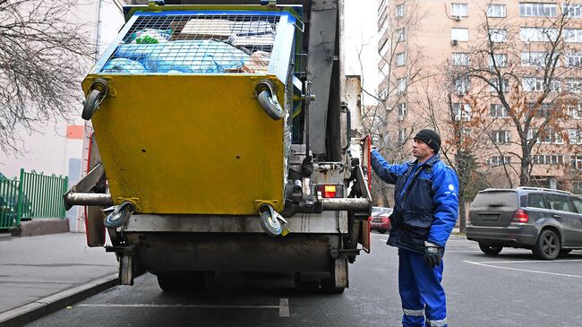 Выгрузка мусора из контейнера в мусоровоз