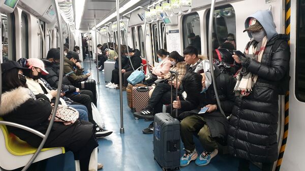 Пассажиры в защитных масках в вагоне метро в Пекине