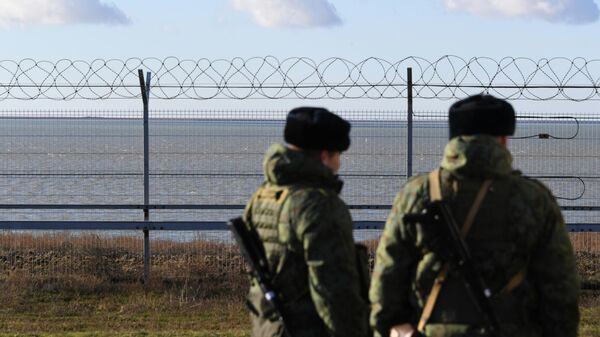 Российские пограничники у заграждения на границе с Украиной