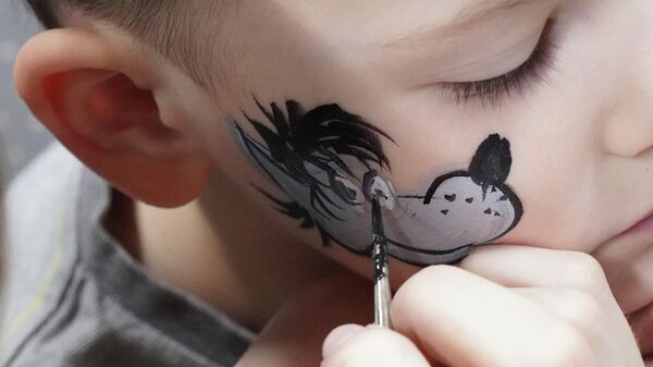 Мальчику рисуют на лице Волка на фестивале киностудии Союзмультфильм в Москве