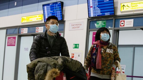 Пассажиры в защитных масках в международном аэропорту Владивостока