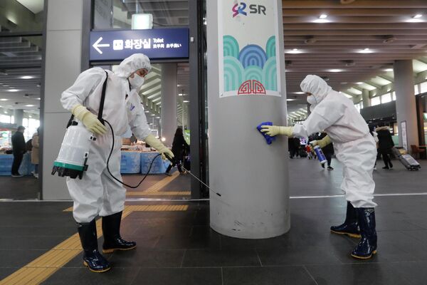 Сотрудники чистят колонну на станции Сусео в Сеуле, Южная Корея