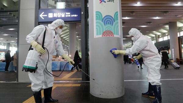 Сотрудники чистят колонну на станции Сусео в Сеуле, Южная Корея