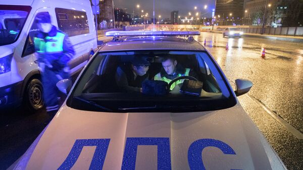 Сотрудник ДПС ГИБДД проводит проверку документов у водителя  в Москве
