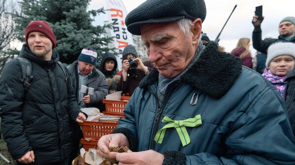 Житель блокадного Ленинграда пробует хлеб, изготовленный на хлебозаводе Ржевка-хлеб по рецепту 1941 года