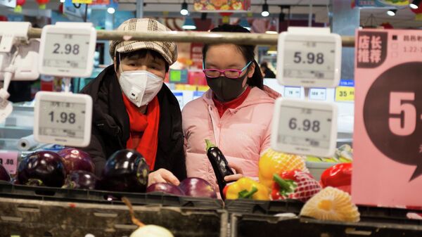 Покупатели выбирают продукты в супермаркете в Пекине, Китай. 25 января 2020 