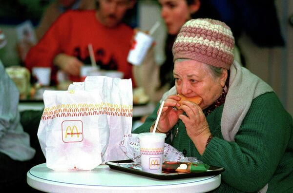 Женщина ест гамбургер в первом Mcdonald's в Москве. 31 января 1990 года