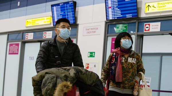 Пассажиры в защитных масках в международном аэропорту Владивостока