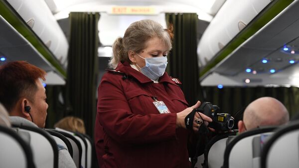 Сотрудница Роспотребназдора обследует при помощи тепловизора пассажиров рейса авиакомпании S7