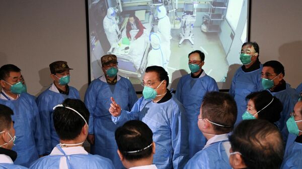 Премьер-министр Китая Ли Кэцян разговаривает с медицинскими работниками в больнице города Ухань, проводят лечение от нового коронавируса