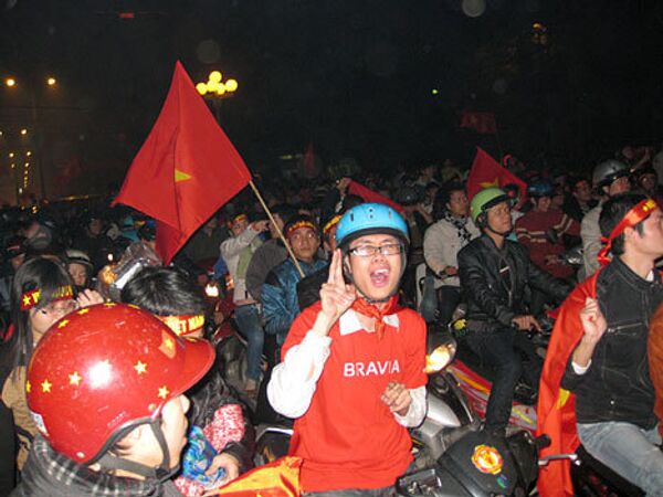 Вьетнамцы празднуют победу по футболу. Сборная команда страны впервые завоевал чемпионский титул