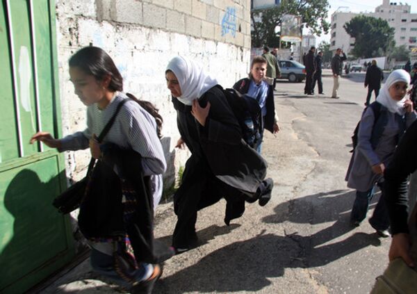 Палестинские женщины и дети бегут в укрытие во время авиаударов израильских ВВС