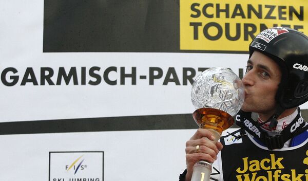 Себастьян Лойтцль целует трофей второго этапа Турнира четырех трамплинов