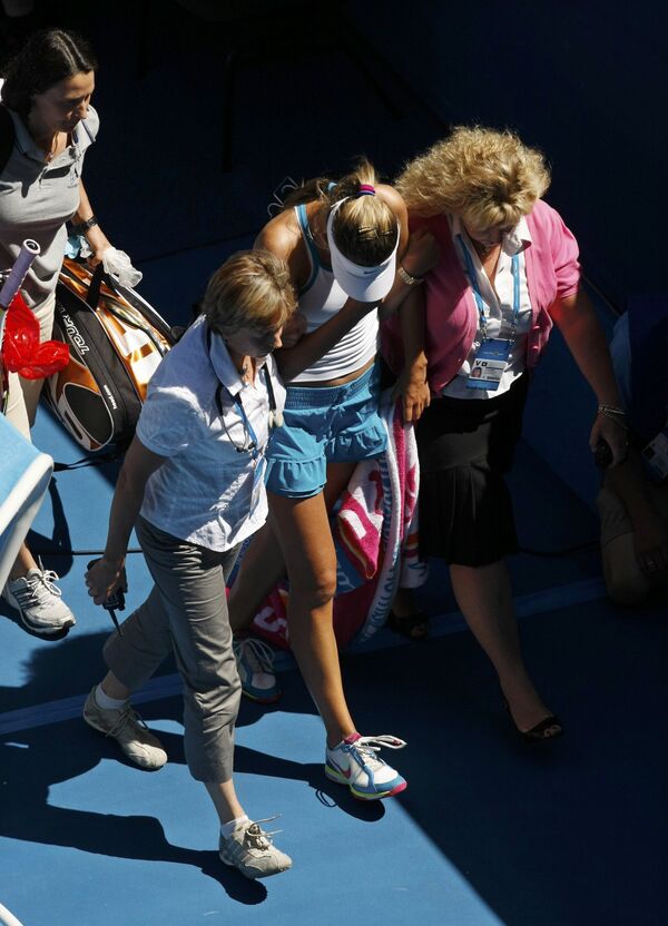 Виктория Азаренко (в центре) покидает корт из-за ухудшившегося состояния во время матча против Серены Уильямс