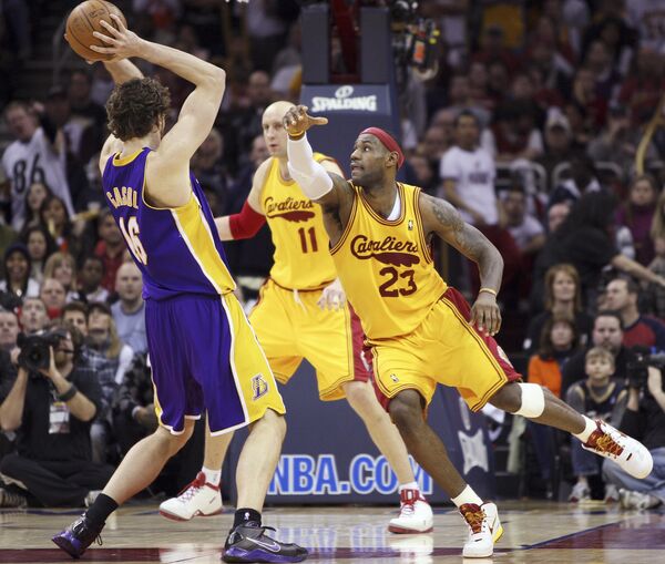 Нападающий Кливленда Леброн Джеймс (справа) мешает центровому Лейкерс По Газолю сделать передачу во время матча НБА