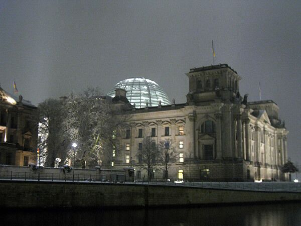 Стеклянный купол здания рейхстага светится в ночное время как маяк