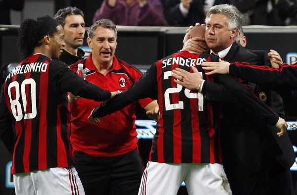 Футболисты Милана Роналдиньо (слева), Филипп Сендерос (в центре) и тренер Карло Анчелотти (справа) празднуют гол в ворота Лечче