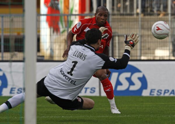 Нападающий Валансьена Йохан Одель (в красном) отправляет мяч в ворота голкипера Лиона Хьюго Лориса