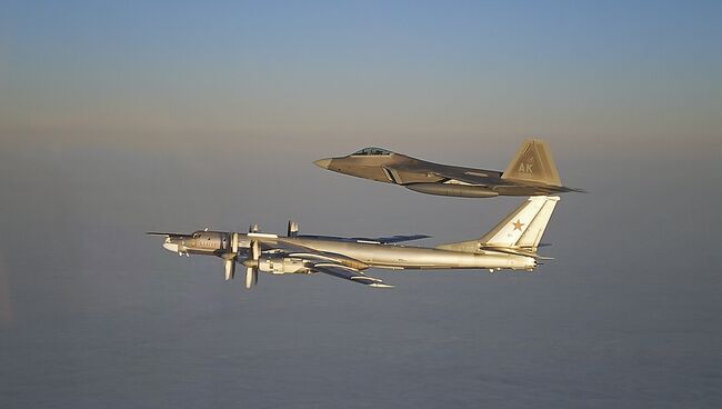 Российский стратегический бомбардировщик Ту-95МС и американский истребитель F-22A Раптор. Архивное фото