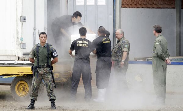 Представители ВВС Бразилии и федеральная полиция готовят контейнеры для перевозки тел погибших в авиакатастрофе 