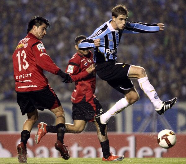 Нападающий бразильского Гремио Эдилсон (справа) борется за мяч с футболистом венесуэльского Каракаса Франклином Лусеной