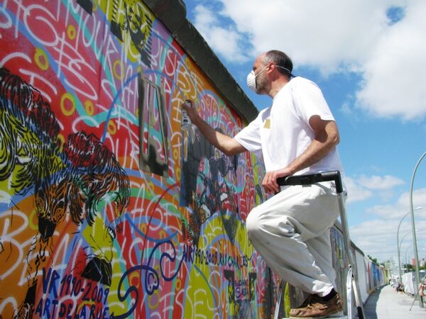 Художники со всего мира реставрируют рисунки на Берлинской стене