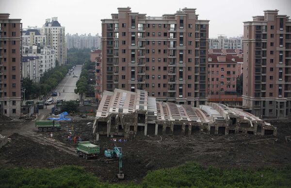 Многоэтажка упала в Шанхае и осталась целой