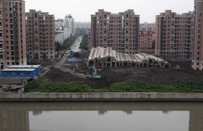 Многоэтажка упала в Шанхае и осталась целой