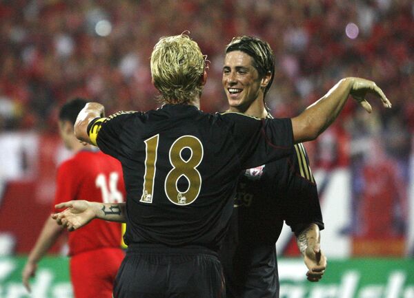 Футболисты Ливерпуля Дирк Кюйт (слева) и Фернандо Торрес празднуют гол в ворота сборной Сингапура в товарищеском матче