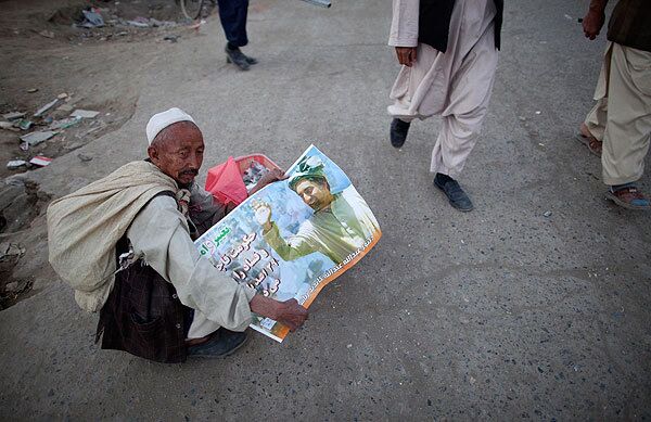 Мужчина держит в руках постер с изображением Абдулы Абдулы, кандидата в президенты Афганистана
