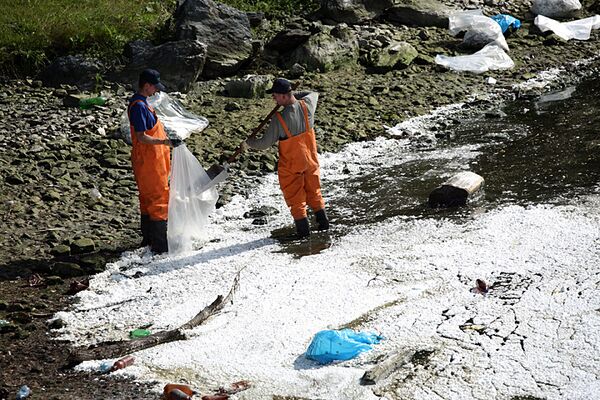 Сотрудники МЧС РФ с помощью абсорбента ликвидируют масляное пятно на реке Енисей