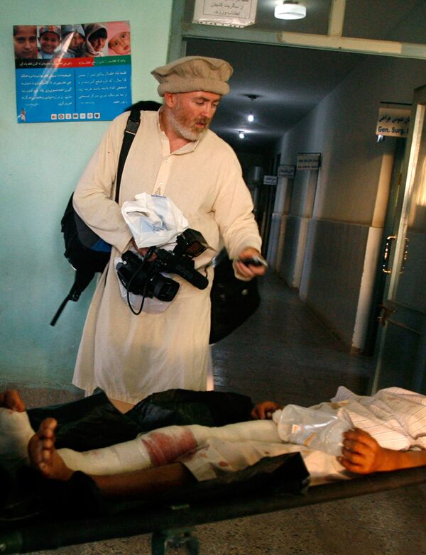 Стивен Фаррелл, британский репортер Нью-Йорк Таймс, снимает раненного человека в больнице города Кундуз 4 сентября 2009