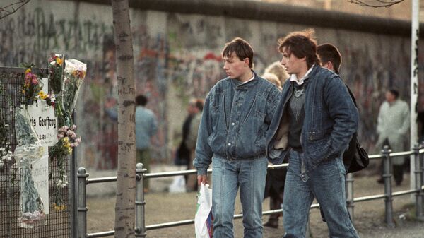 Жители Берлина рассматривают кресты у Берлинской стены