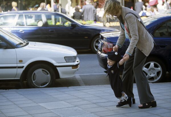 Молодая женщина с ребенком на городской улице. Архив