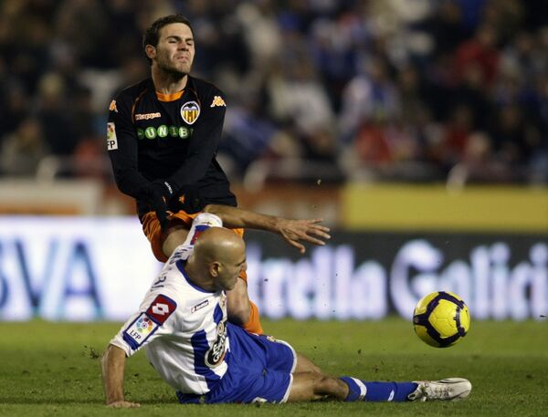 Защитник Депортиво Мануэль Пабло (на траве) и нападающий Валенсии Хуан Мануэль Мата