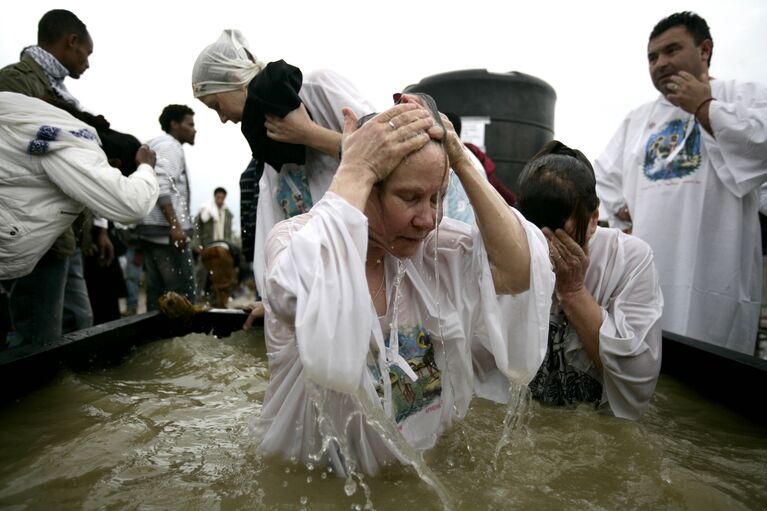 Православные паломники совершают омовение в купелях, наполненных водой из Иордана