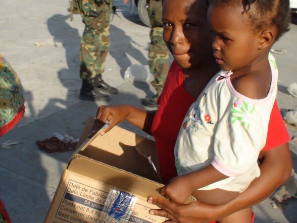 Пострадавшие от разрушительного землетрясения гаитянцы у пункта раздачи гуманитарной в столице Гаити Порт-о-Пренсе.