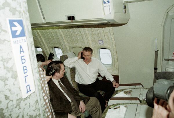Владимир Жириновский разговаривает по телефону в салоне самолета