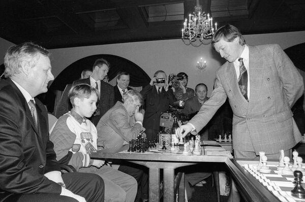 Гроссмейстер Анатолий Карпов играет в шахматы с мэром Санкт-Петербурга Собчаком и его внуком