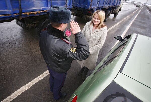 Сотрудник ДПС поздравиляет женщину-водителя с 8 Марта. Архив