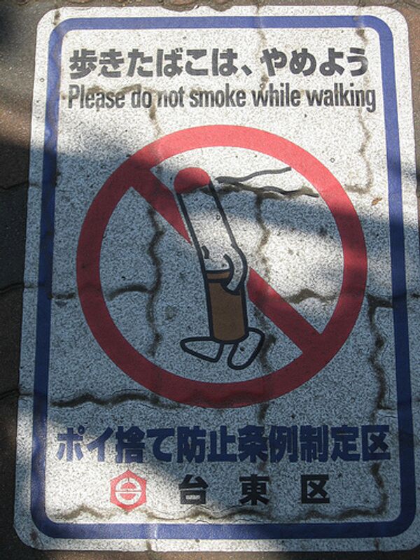 Размещенный в Токио плакат, призывающий не курить во время ходьбы