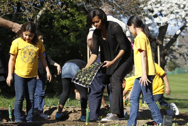 Первая леди США Мишель Обама сажает овощи на огороде Белого дома. 2010 год.