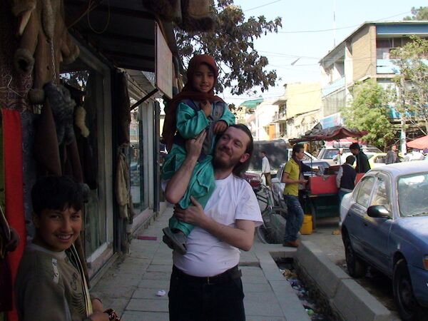 Отец Петр Гайдук держит на плечах афганского ребенка