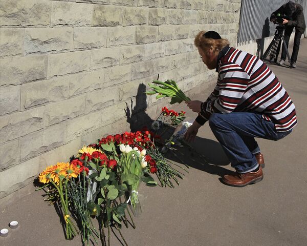 В знак скорби люди приносят цветы к посольству Польши в Москве