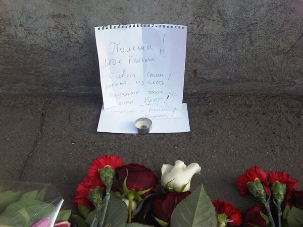 Москвичи несут цветы к посольству Польши в Москве