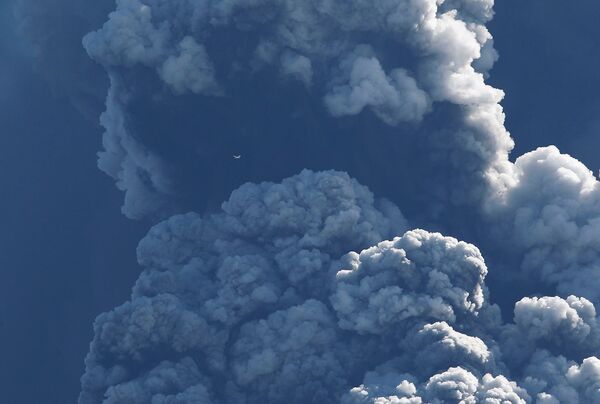 Самолет пролетает над местом извержения вулкана, расположенного на леднике Эйяфьятлайокудль