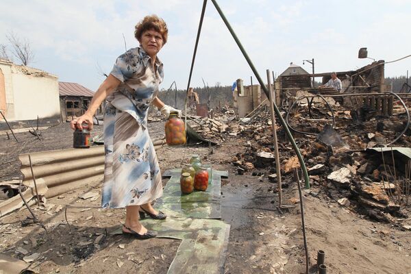 Жительница поселка Масловка (микрорайон города Воронежа) у своего сгоревшего дома. Архив