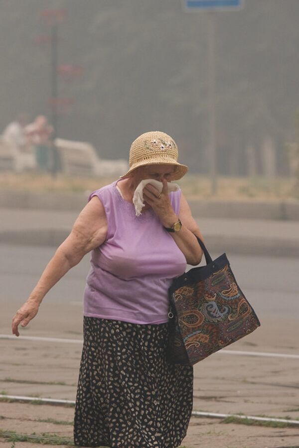 Пенсионерка спасается от дыма в Москве