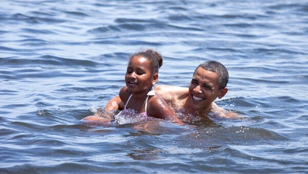 Президент Барак Обама с дочерью Сашей купаются во время поездки во Флориду 14 августа 2010 г. 